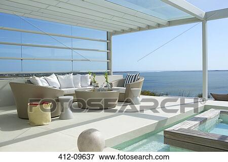 Sofa and chairs by swimming pool overlooking ocean View Large Photo Image Stock Photo - Sofa and chairs by swimming pool overlooking ocean. Fotosearch