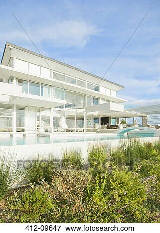 Swimming pool and landscaping outside modern house View Large Photo Image Stock Photo - Swimming pool and landscaping outside modern house. Fotosearch