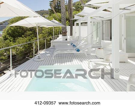 Swimming pool and lounge chairs on patio View Large Photo Image Stock Photo - Swimming pool and lounge chairs on patio. Fotosearch