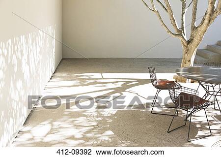 Table and chairs casting shadows in courtyard View Large Photo Image Stock Image - Table and chairs casting shadows in courtyard. Fotosearch