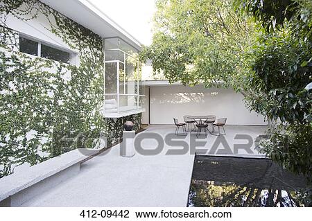 Table and chairs in modern courtyard View Large Photo Image Stock Image - Table and chairs in modern courtyard. Fotosearch