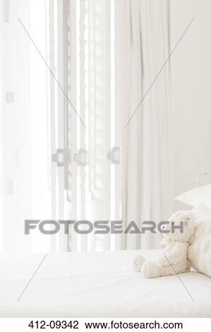 Teddy bear on white bed View Large Photo Image Stock Image - Teddy bear on white bed. Fotosearch