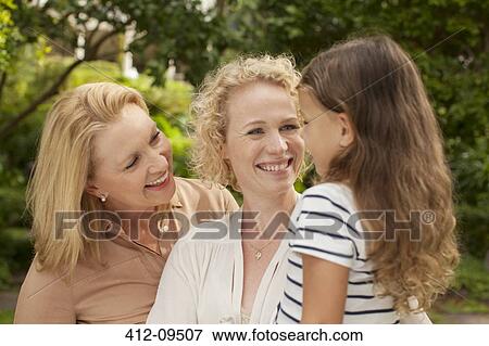 Stock Photo - Three generations of women smiling outdoors. Fotosearch