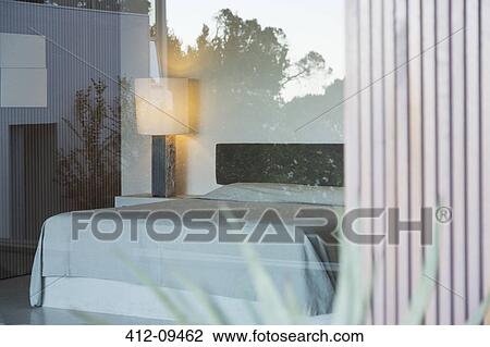 Stock Image - View of modern bedroom through window. Fotosearch