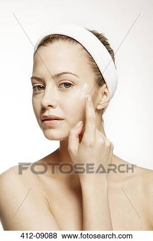 Woman applying moisturizer to face View Large Photo Image Stock Photo - Woman applying moisturizer to face. Fotosearch