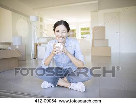 Woman drinking coffee among cardboard boxes View Large Photo Image Picture - Woman drinking coffee among cardboard boxes. Fotosearch