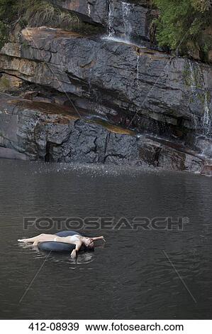 Woman floating in inner tube on river View Large Photo Image Stock Photo - Woman floating in inner tube on river. Fotosearch