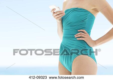 Woman in bathing suit using cell phone View Large Photo Image Stock Image - Woman in bathing suit using cell phone. Fotosearch