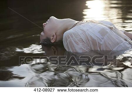 Stock Photo - Woman leaning head back in river. Fotosearch