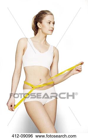 Stock Photograph - Woman measuring her waist. Fotosearch