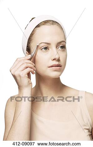 Woman plucking her eyebrows View Large Photo Image Stock Photo - Woman plucking her eyebrows. Fotosearch