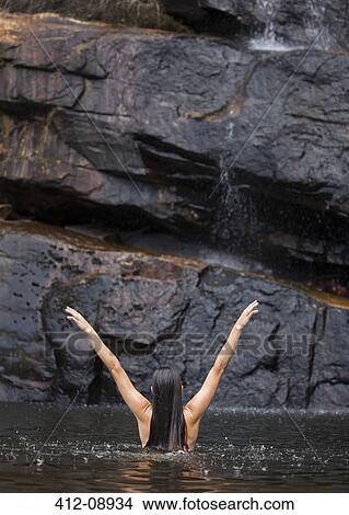 Woman standing in pool with arms outstretched View Large Photo Image Picture - Woman standing in pool with arms outstretched. Fotosearch