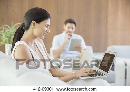 Woman using laptop on sofa View Large Photo Image Stock Image - Woman using laptop on sofa. Fotosearch