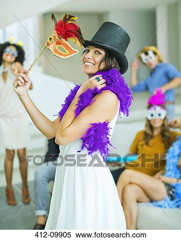 Stock Photography - Woman wearing decorative hat with mask at party. Fotosearch
