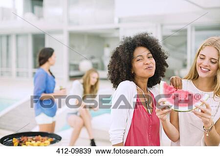 Women eating watermelon at barbecue View Large Photo Image Stock Photo - Women eating watermelon at barbecue. Fotosearch