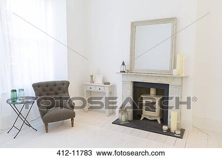 Stock Image - Armchair and fireplace in living room. Fotosearch