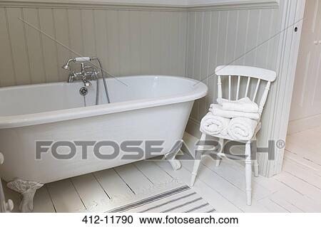 Stock Image - Bathtub and chair in ornate bathroom. Fotosearch