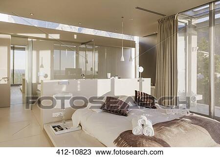 Stock Image - Bed and bathroom in modern master bedroom. Fotosearch