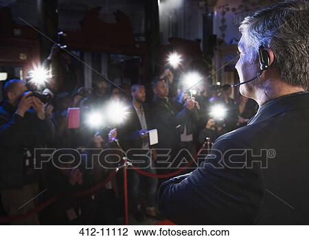 Stock Image - Bodyguard watching paparazzi at red carpet event. Fotosearch