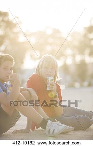 Boys drinking juice outdoors View Large Photo Image Stock Image - Boys drinking juice outdoors. Fotosearch