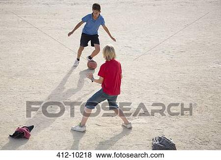 Boys playing with soccer ball in sand View Large Photo Image Stock Photo - Boys playing with soccer ball in sand. Fotosearch