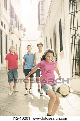 Boys watching girl play with soccer ball in alley View Large Photo Image Stock Image - Boys watching girl play with soccer ball in alley. Fotosearch