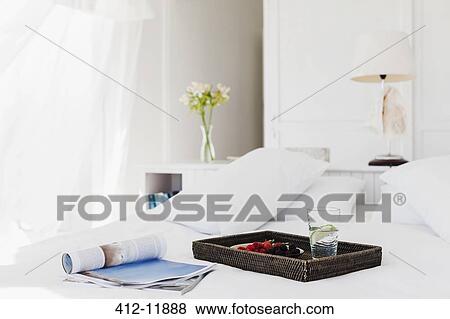 Stock Photo - Breakfast tray and magazine on bed. Fotosearch