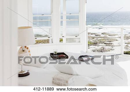 Breakfast tray and magazine on bed overlooking ocean View Large Photo Image Stock Photo - Breakfast tray and magazine on bed overlooking ocean. Fotosearch
