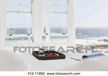 Breakfast tray and magazine on bed overlooking ocean View Large Photo Image Stock Photography - Breakfast tray and magazine on bed overlooking ocean. Fotosearch