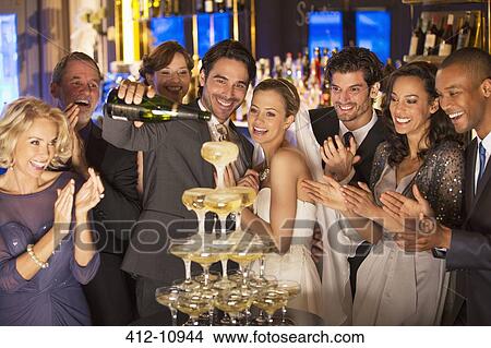 Bride and group pouring champagne pyramid at wedding reception View Large Photo Image Picture - Bride and group pouring champagne pyramid at wedding reception. Fotosearch