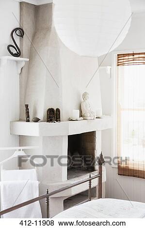 Stock Photo - Buddha on fireplace in bedroom. Fotosearch