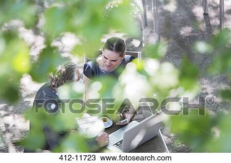 Stock Image - Business people talking at sidewalk cafe. Fotosearch