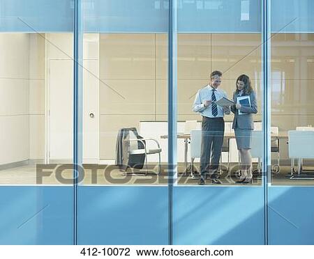 Stock Image - Business people talking in conference room. Fotosearch