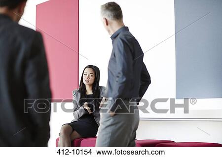 Picture - Business people talking in lobby. Fotosearch