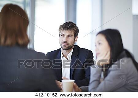 Stock Image - Business people talking in meeting. Fotosearch