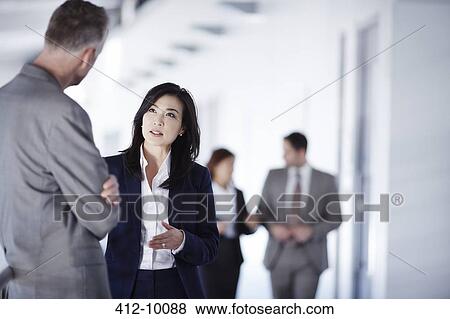 Business people talking in office corridor View Large Photo Image Stock Photo - Business people talking in office corridor. Fotosearch