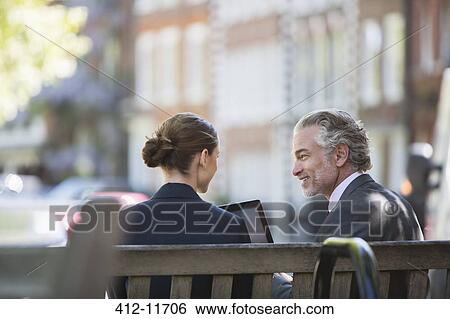 Business people talking on urban bench View Large Photo Image Stock Photograph - Business people talking on urban bench. Fotosearch