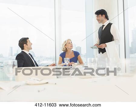 Business people talking to waiter in restaurant View Large Photo Image Stock Image - Business people talking to waiter in restaurant. Fotosearch