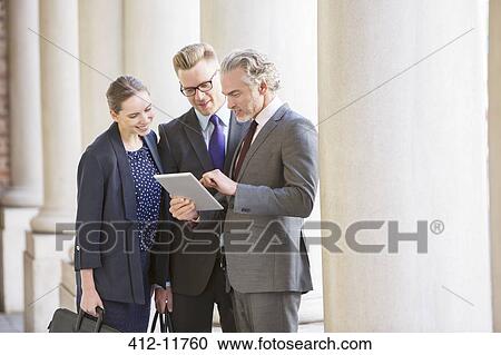 Business people using digital tablet outdoors View Large Photo Image Stock Image - Business people using digital tablet outdoors. Fotosearch