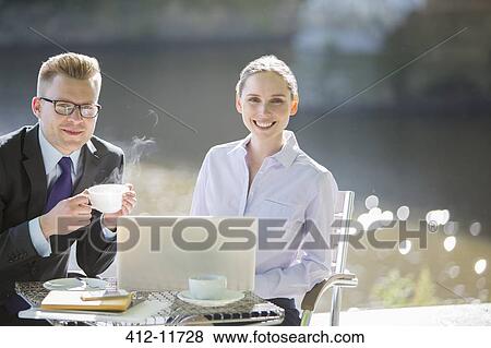 Stock Photo - Business people working at sidewalk cafe. Fotosearch