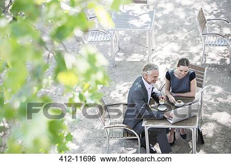 Business people working at sidewalk cafe View Large Photo Image Stock Photograph - Business people working at sidewalk cafe. Fotosearch