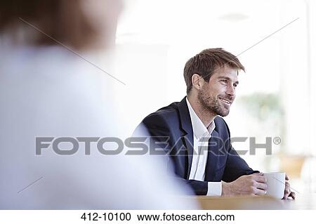 Stock Image - Businessman drinking cup of coffee in cafe. Fotosearch