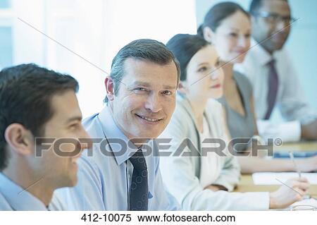Businessman smiling in meeting View Large Photo Image Stock Photography - Businessman smiling in meeting. Fotosearch
