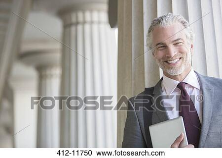 Stock Image - Businessman smiling outdoors. Fotosearch