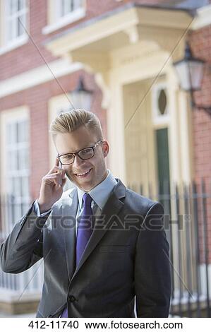 Businessman talking on cell phone outdoors View Large Photo Image Stock Image - Businessman talking on cell phone outdoors. Fotosearch