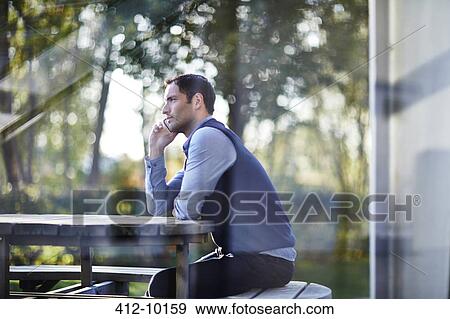 Stock Photo - Businessman talking on cell phone outside. Fotosearch
