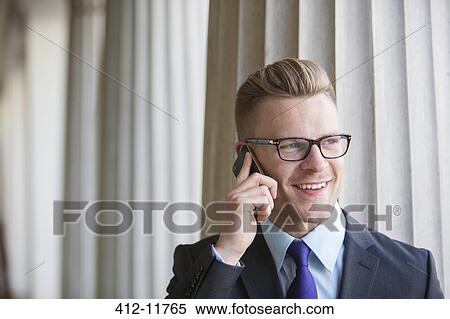 Stock Photography - Businessman talking on cell phone outdoors. Fotosearch
