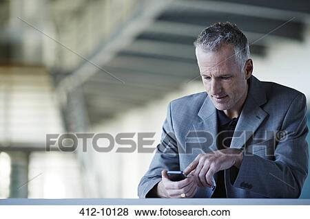 Businessman using cell phone View Large Photo Image Stock Photo - Businessman using cell phone. Fotosearch