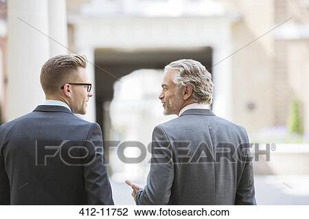 Stock Image - Businessmen talking on city street. Fotosearch