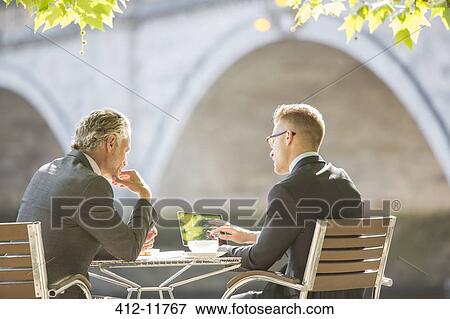 Businessmen working at sidewalk cafe View Large Photo Image Stock Photo - Businessmen working at sidewalk cafe. Fotosearch